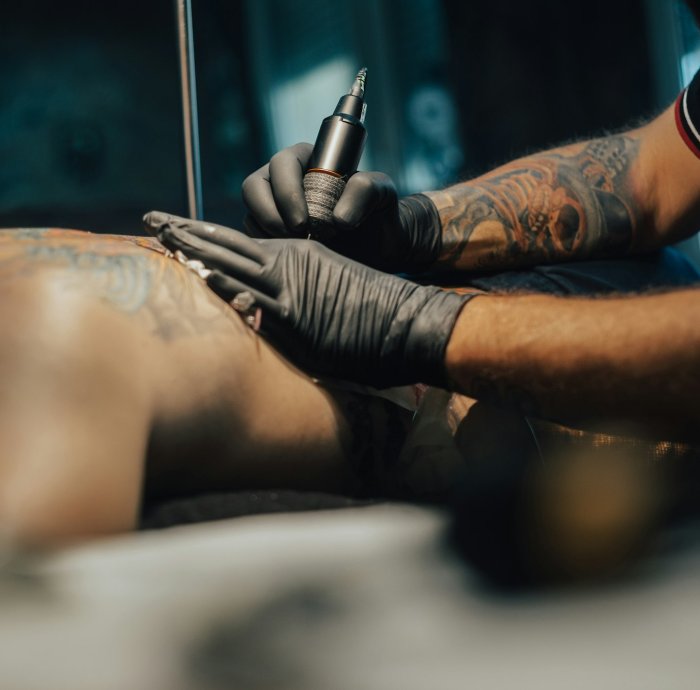 Tattoo artist holding a machine while working in a studio