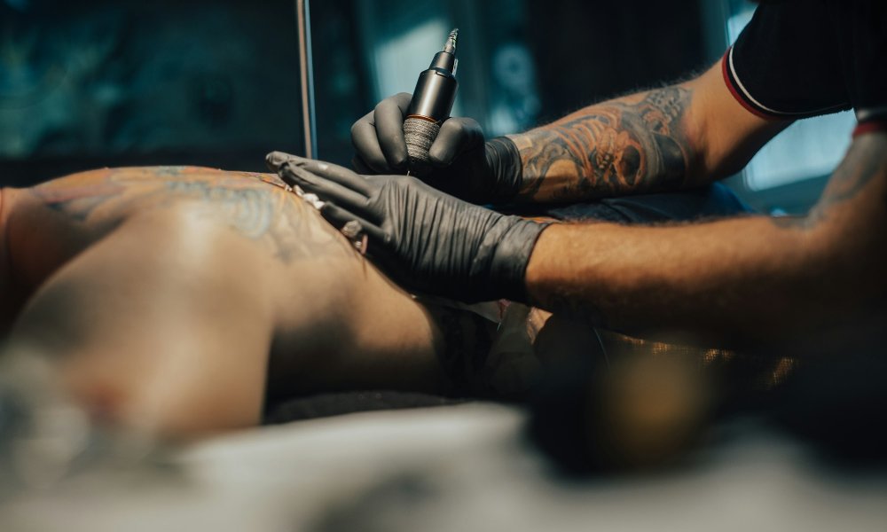 Tattoo artist holding a machine while working in a studio